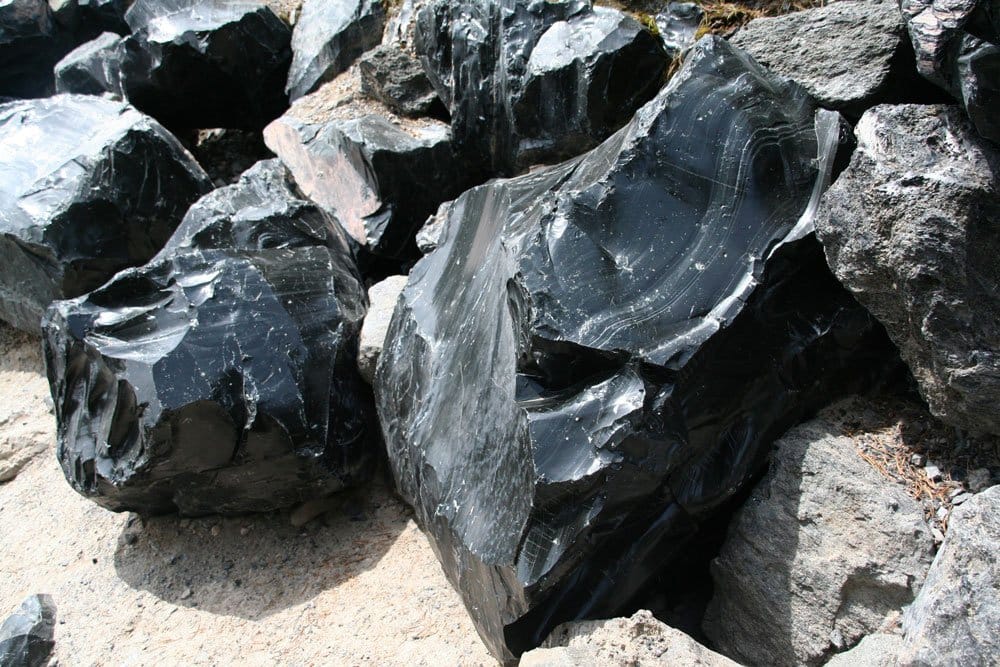 Pierre obsidienne origine composition — bloc d'obsidienne noire et coulée de lave rhyolitique volcan silice