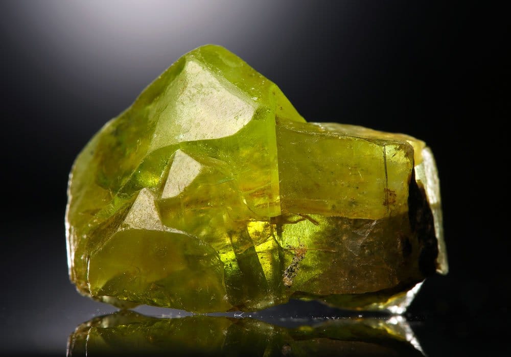 Cristal de péridot brut vert olive sur basalte — origine géologique et composition du péridot