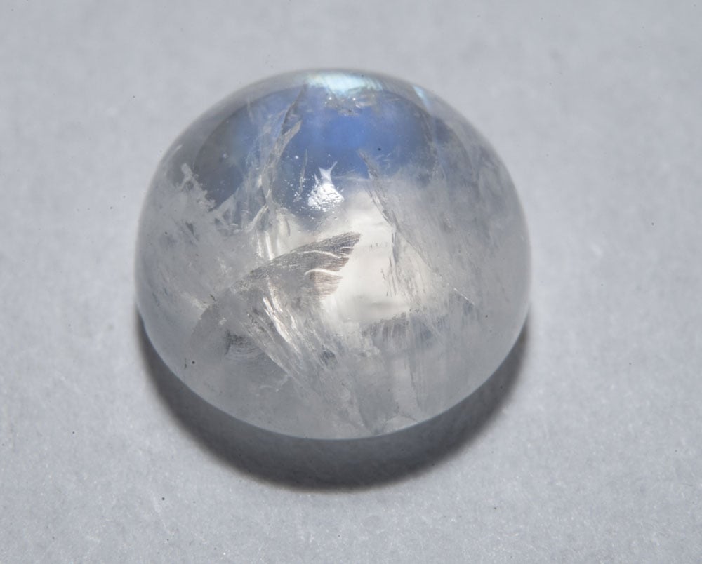 Labradorite blanche brute montrant son fond blanc laiteux et ses reflets nacrés bleutés — variété d'albite péristérite