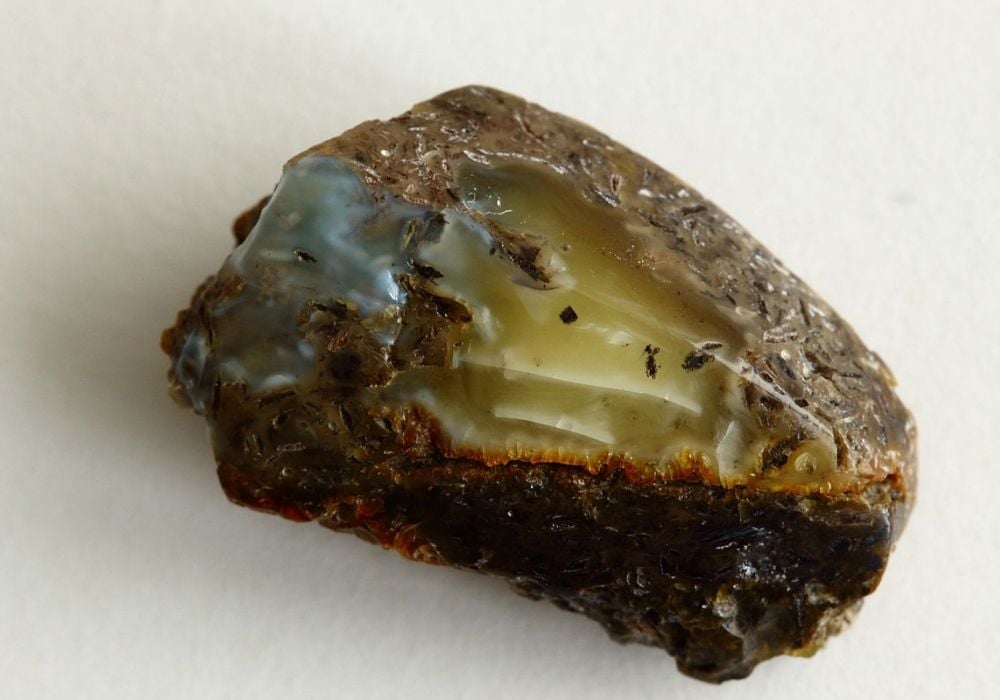 Ambre Bleue brute en lumière naturelle et ultraviolette, gemme fossile rare de République Dominicaine