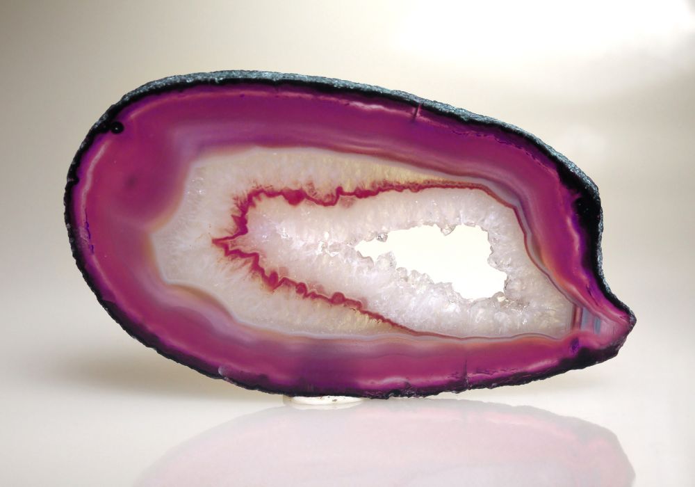 Détail des bandes d'agate teintée rose et violet intensément colorées — cristaux microfibrillaires saturés de colorants