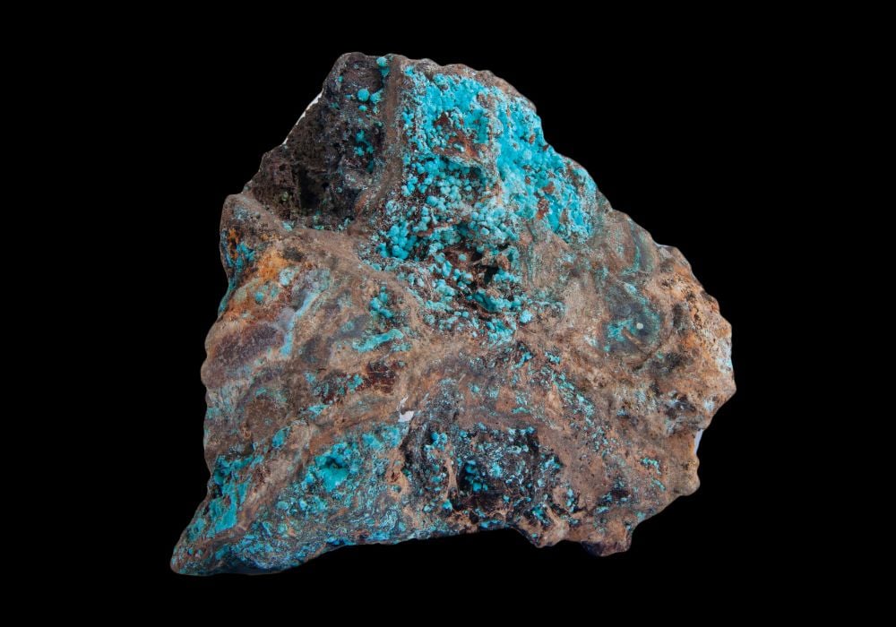 Agrégat d'Aurichalcite montrant ses cristaux aciculaires bleu-vert sur matrice rocheuse