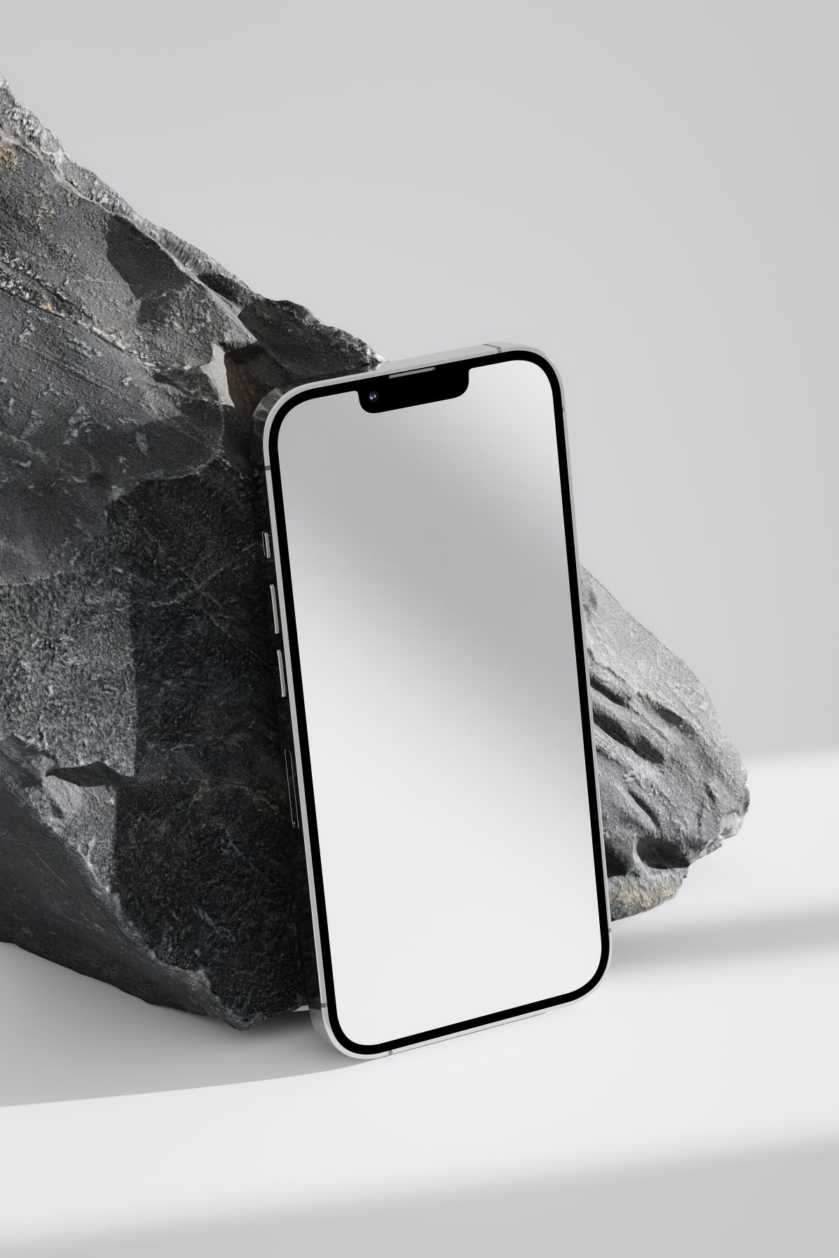 Smartphone posé contre un bloc de roche sombre